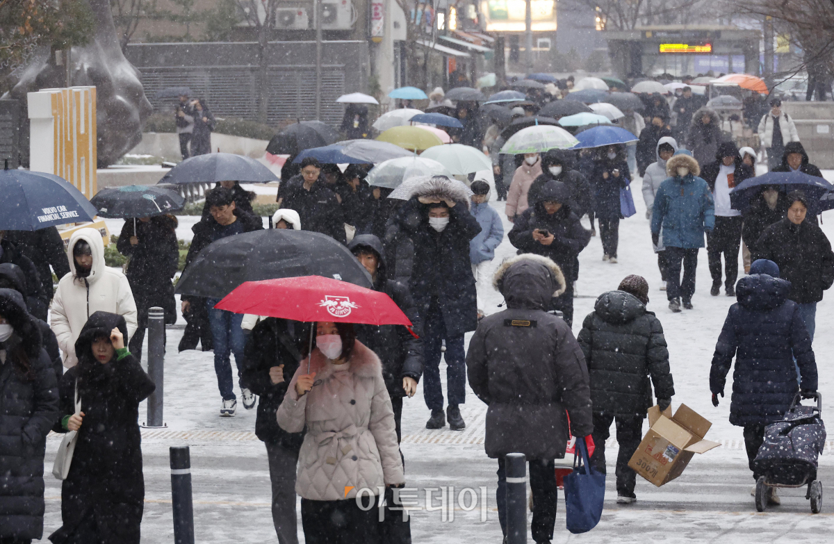 ▲전국 대부분 지역에 눈이 내린 9일 오전 서울 영등포구 여의도역 일대에서 직장인들이 눈을 피해 출근길 발걸음을 재촉하고 있다. 조현호 기자 hyunho@