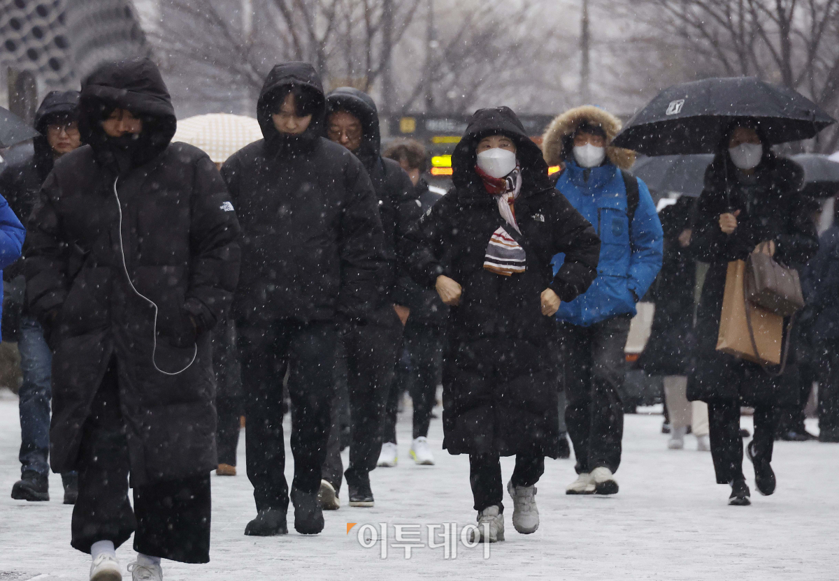 ▲전국 대부분 지역에 눈이 내린 9일 오전 서울 영등포구 여의도역 일대에서 직장인들이 눈을 피해 출근길 발걸음을 재촉하고 있다. 조현호 기자 hyunho@