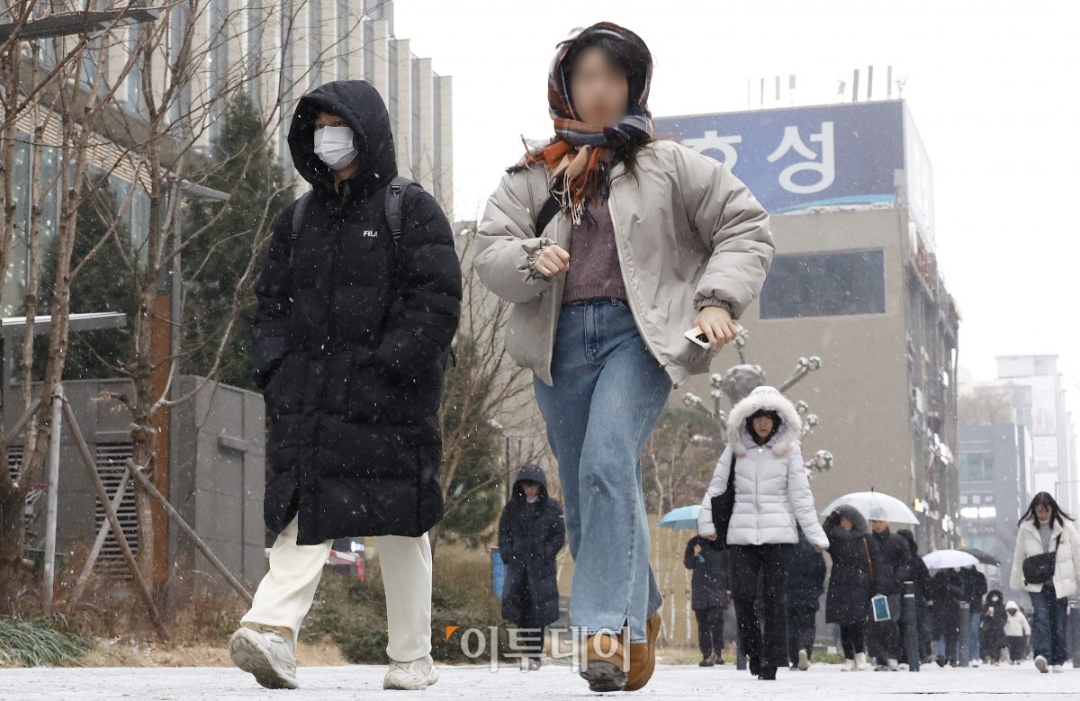 ▲전국 대부분 지역에 눈이 내린 9일 오전 서울 영등포구 여의도역 일대에서 직장인들이 눈을 피해 출근길 발걸음을 재촉하고 있다. 조현호 기자 hyunho@