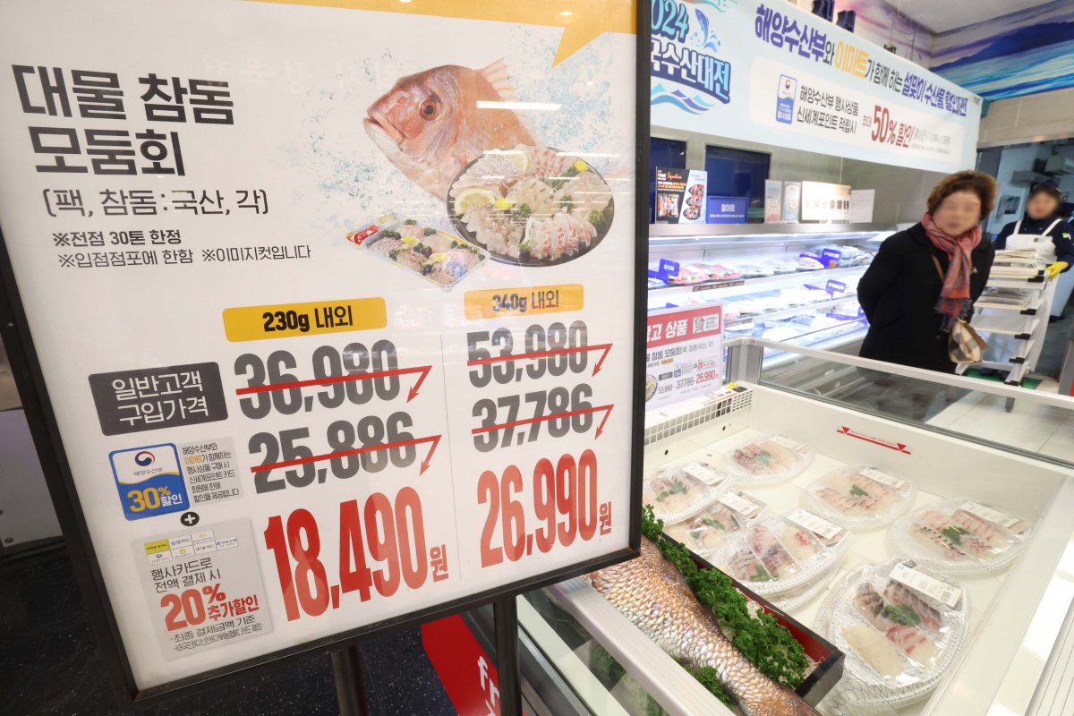 ▲고물가에 소비심리가 얼어붙자 유통업계가 연초부터 ‘반값 마케팅’에 나선 가운데 12일 서울 용산구 이마트 용산점에 반값 생선회 광고가 게시돼 있다. 신태현 기자 holjjak@
