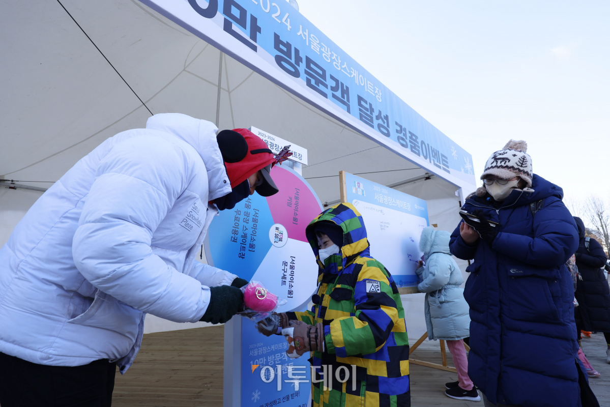 ▲23일 서울 중구 서울광장 스케이트장에서 열린 방문객 10만 명 돌파 기념 행사에서 시민들이 경품 이벤트를 하고 있다. 조현호 기자 hyunho@