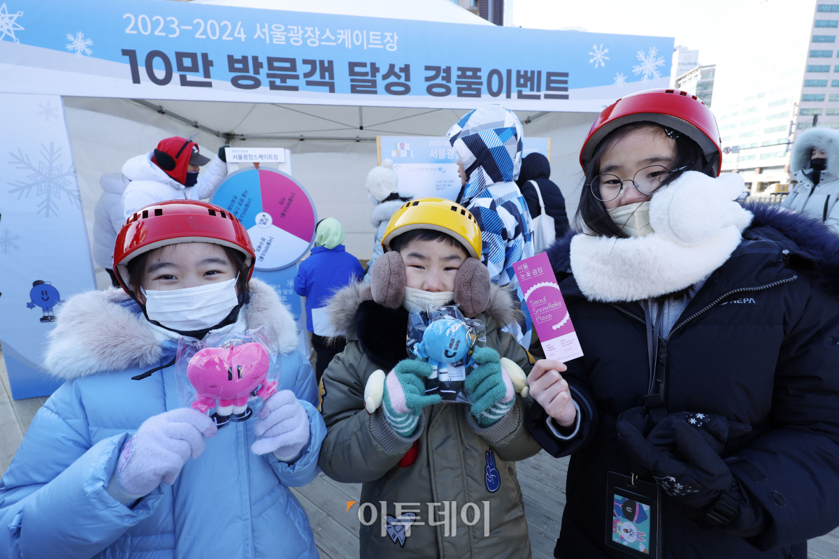 ▲23일 서울 중구 서울광장 스케이트장에서 열린 방문객 10만 명 돌파 기념 행사에서 경품 이벤트 참여 후 선물을 받은 아이들이 선물을 들어보이고 있다. 조현호 기자 hyunho@