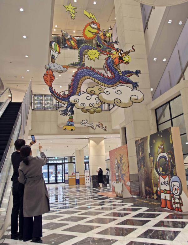 ▲관람객들이 광주신세계백화점에 전시된 황중환 작가의 '구름 속 쌍룡'을 보고 있다. (사진제공=신세계백화점)