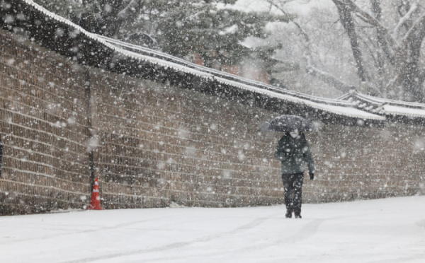 ▲서울지역에 대설주의보가 내려진 지난달 30일 서울 종로구 세종대로 일대에서 한 시민이 우산을 쓰고 지나가고 있다. (뉴시스)