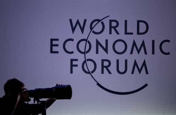 ▲15일(현지시간) 스위스 다보스에서 열린 세계경제포럼(WEF) 개막식에서 한 사진기자가 로고 옆에서 촬영을 하고 있다. 다보스(스위스)/AFP연합뉴스
