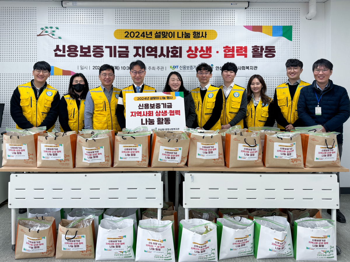 ▲심현구 신용보증기금 전무이사를 포함한 신용보증기금 임직원들과 대구 안심제1종합사회복지관 직원들이 설맞이 사회공헌활동 기념 촬영을 하고 있다. (사진제공=신보)