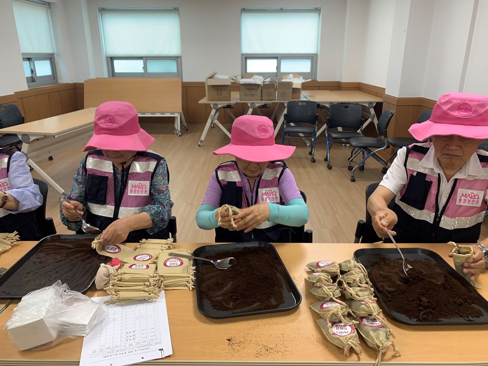 ▲수거한 커피박으로 친환경 탈취제를 제작하고 있는 우리동네 환경보안관. (자료제공=마포구)