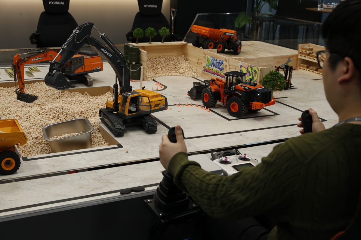 ▲기자가 RC 건설장비를 조종하는 모습. (사진제공=HD현대사이트솔루션)