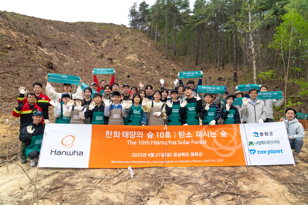 ▲한화 임직원들이 태양의 숲 조성 부지 앞에서 단체 사진을 찍고 있다. (사진제공=한화그룹)