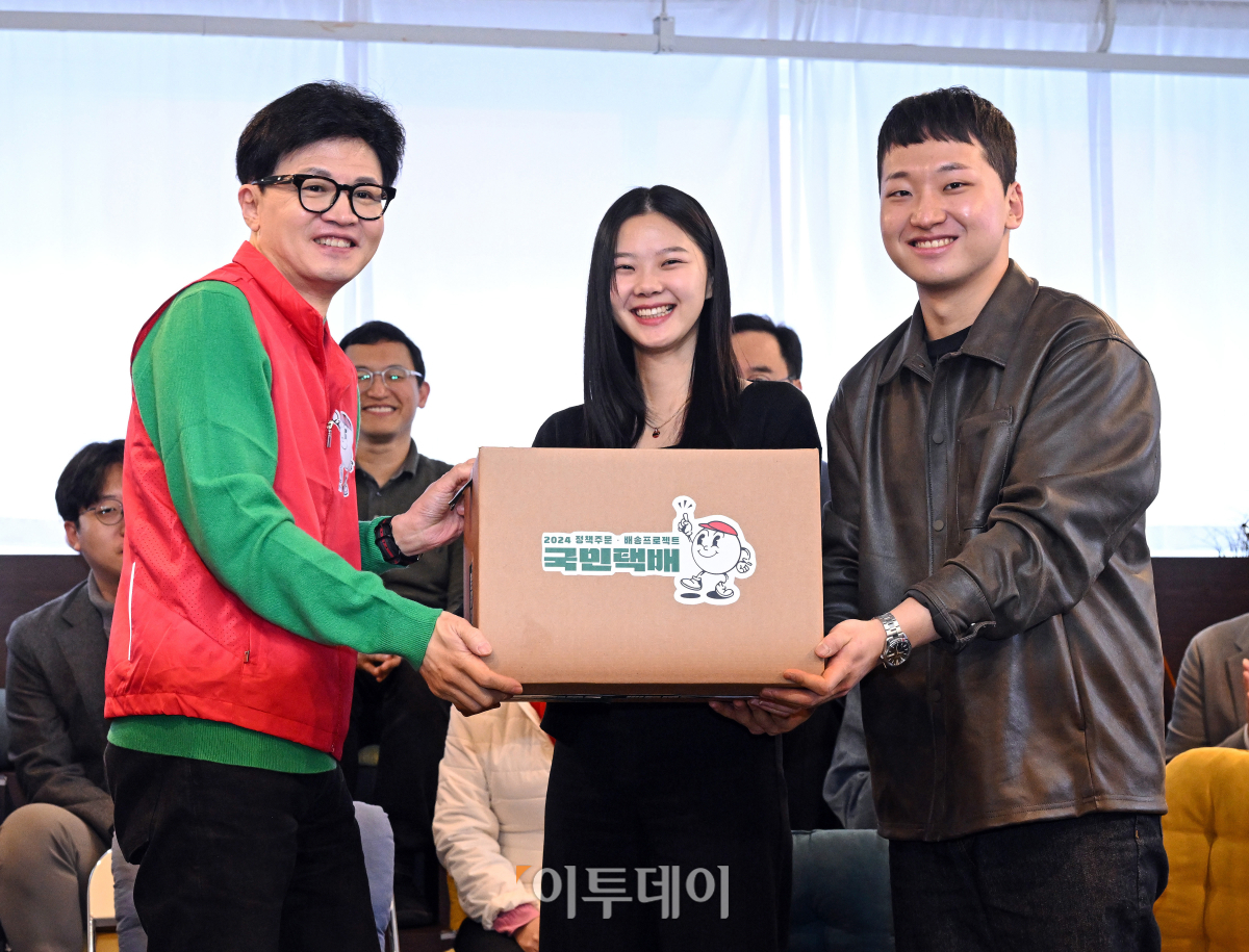 ▲한동훈 국민의힘 비상대책위원장이 27일 서울 성동구의 한 북카페에서 기후 미래 스타트업 창업자들에게 기후 미래 택배를 전달하고 있다. 조현호 기자 hyunho@