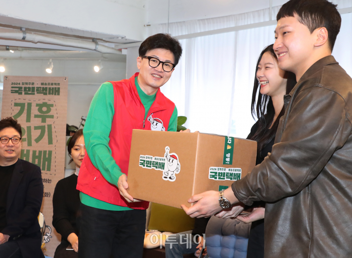 ▲한동훈 국민의힘 비상대책위원장이 27일 서울 성동구의 한 북카페에서 기후 미래 스타트업 창업자들에세 기후 미래 택배를 전달하고 있다. 조현호 기자 hyunho@