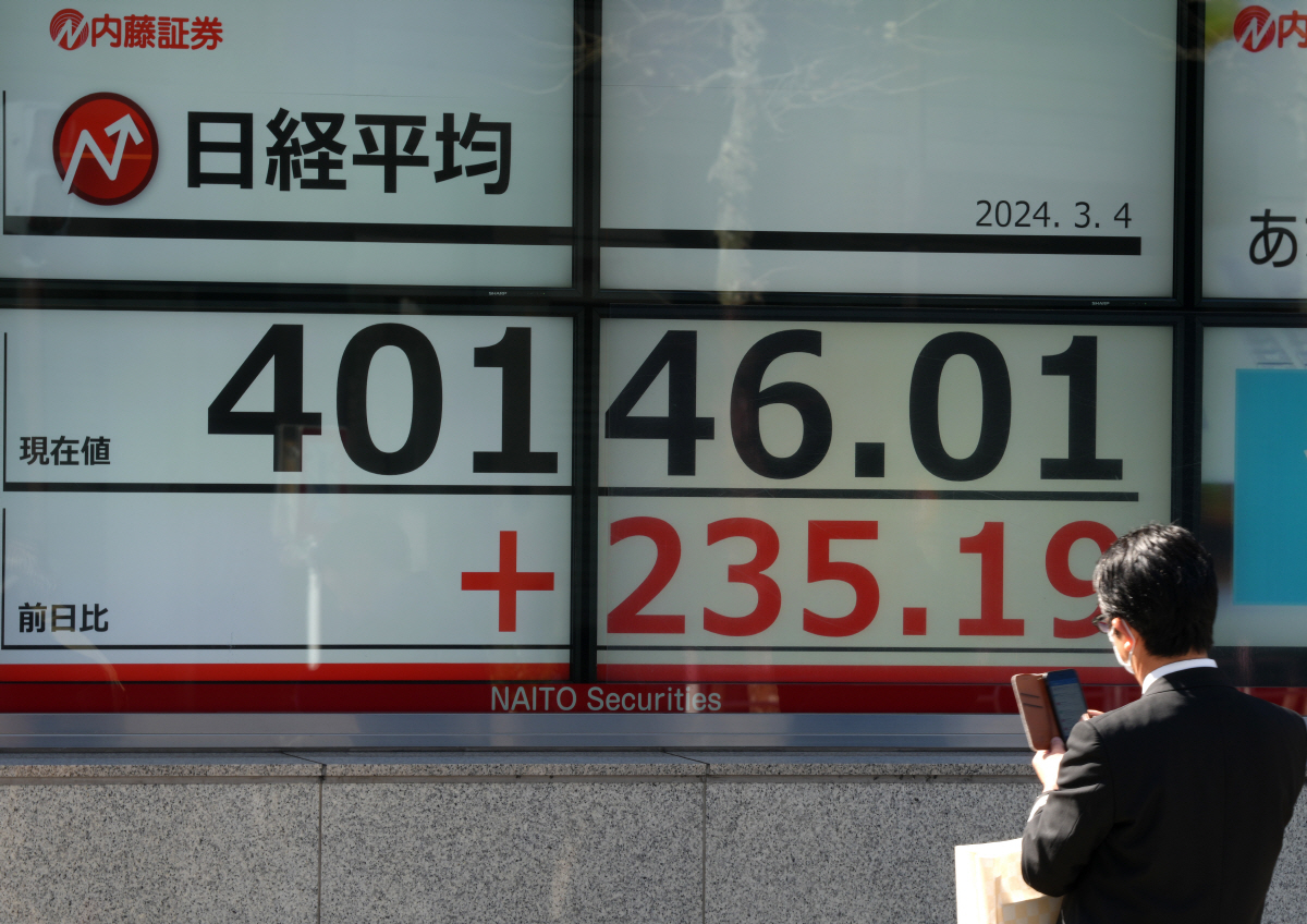 ▲일본 도쿄의 한 증권사 앞에서 4일 닛케이225지수가 4만 선을 돌파한 것이 표시된 전광판을 행인이 스마트폰으로 촬영하고 있다. 도쿄/EPA연합뉴스
