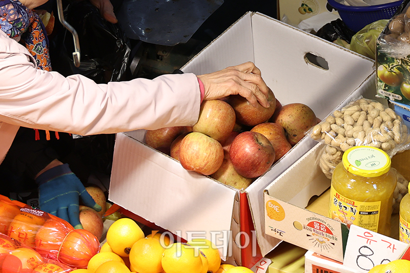 ▲13일 경기 부천 삼산농산물 도매시장에서 시민이 못난이 사과를 구입하고 있다. 고이란 기자 photoeran@
