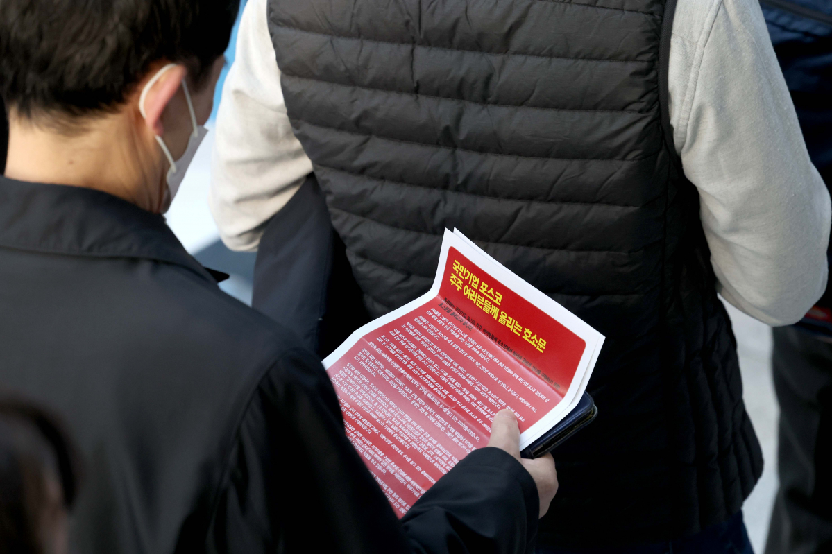 ▲21일 서울 강남구 포스코센터에서 열린 포스코홀딩스 정기 주주총회에 한 주주가 입장하며 금속노조 포스코지회가 배포한 유인물을 살펴보고 있다. 이날 주총엔 장인화 대표이사 회장 후보를 비롯한 사내이사 선임안, 사외이사 선임안, 2023년 재무제표 승인안, 정관 일부 변경안, 이사 보수한도 승인안 등이 상정됐다. 신태현 기자 holjjak@