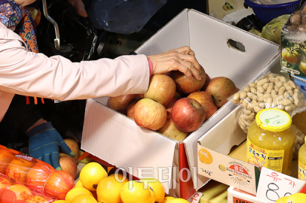 ▲13일 경기 부천 삼산농산물 도매시장에서 시민이 못난이 사과를 구입하고 있다. 고이란 기자 photoeran@