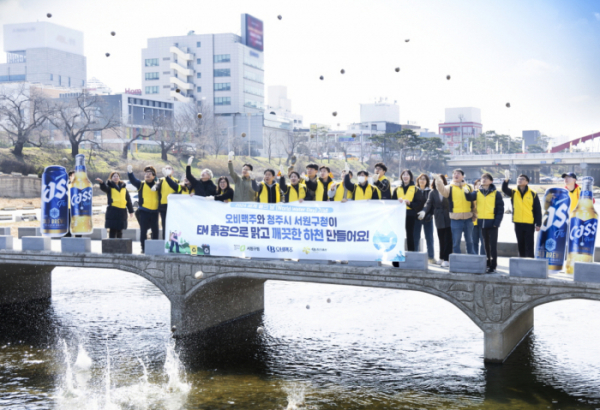 ▲21일 오비맥주 청주공장 임직원들이 서원구청 관계자들과청주시 무심천에서 ‘EM 흙공 던지기’를 하며 하천 정화 활동을 펼치고 있다.  (사진제공=오비맥주)