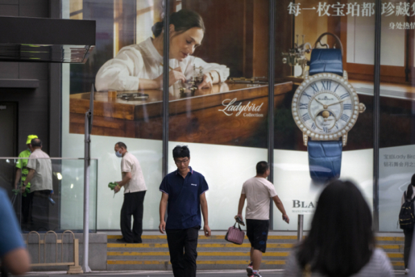 ▲중국 베이징에서 행인들이 명품 브랜드 광고판 앞을 지나고 있다. 베이징/AP뉴시스