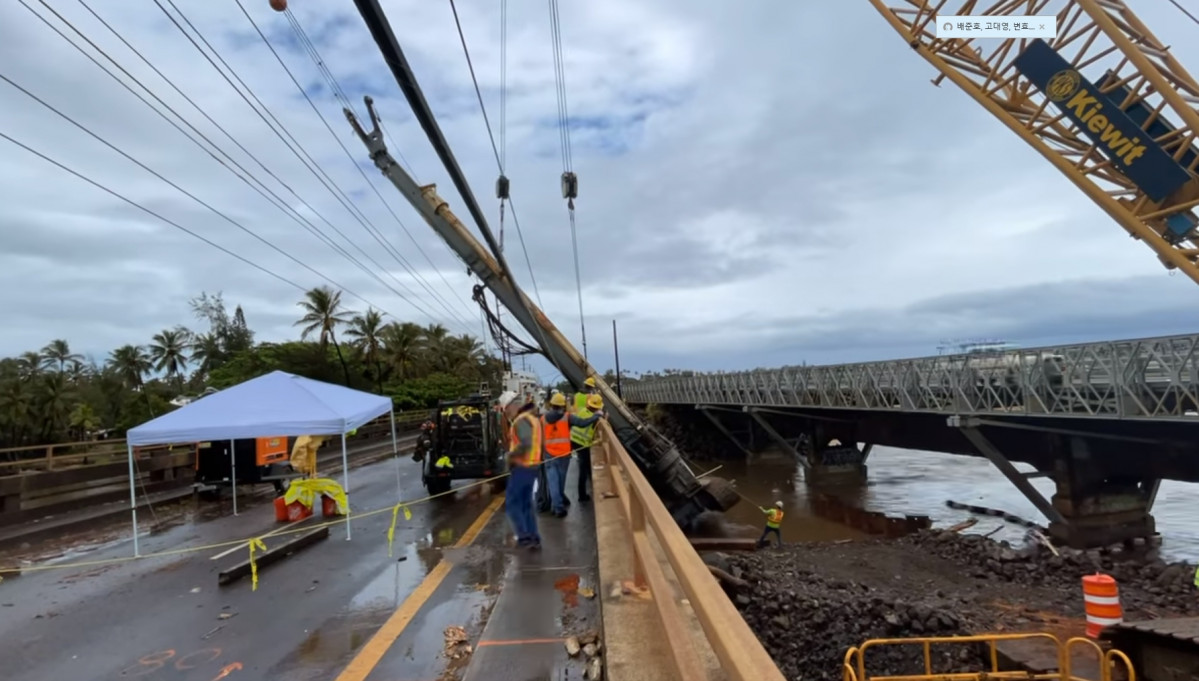 ▲폭우를 동반한 홍수로 인해 하와이주 당국이 비상사태를 선포했다. 사진은 11일(현지시간), 강 범람으로 인해 통제된 교각을 복구하는 모습.  (출처 하와이교통국)