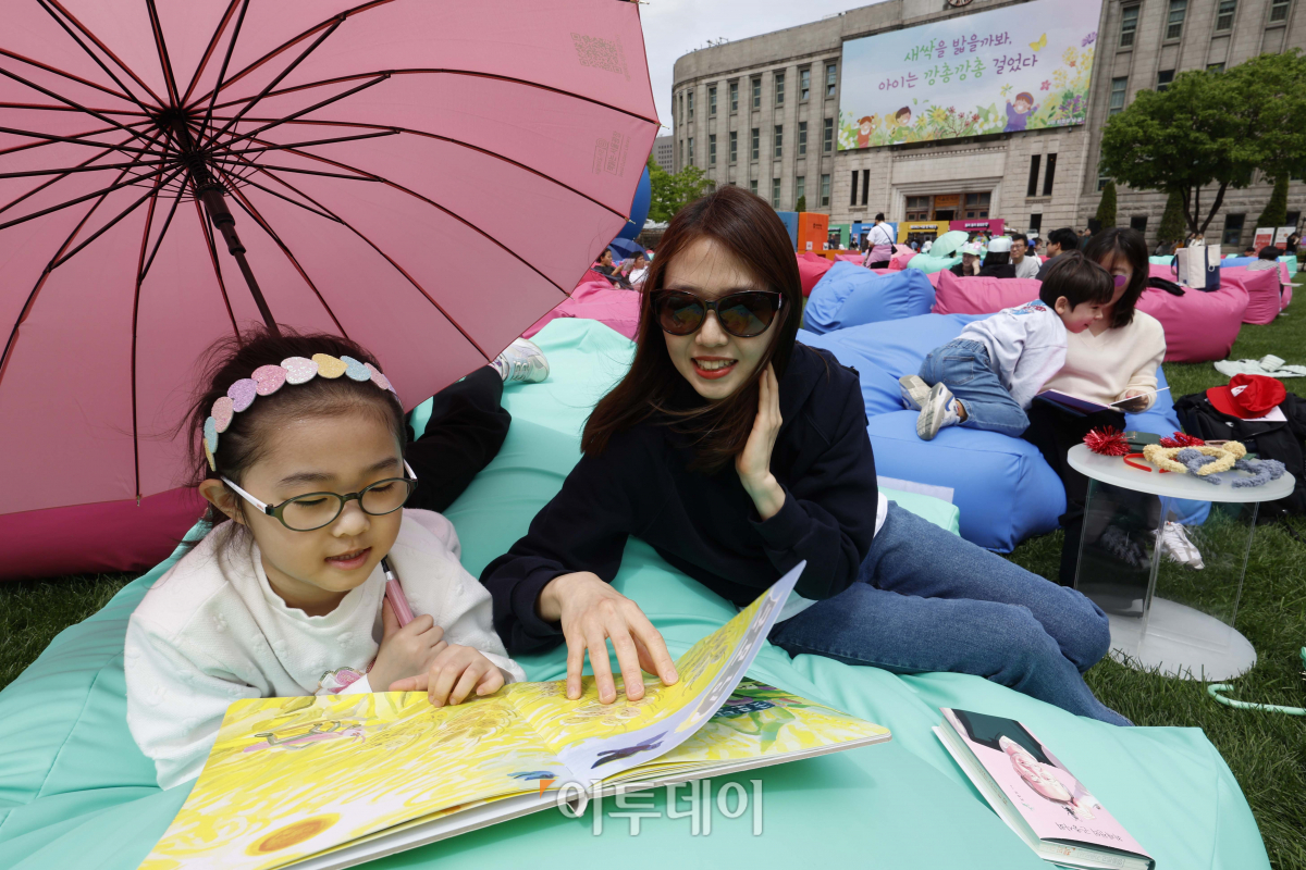 ▲서울야외도서관 개장 후 첫 주말을 맞은 21일 서울 중구 서울광장에 마련된 책읽는 서울광장을 찾은 시민들이 독서를 하며 휴식을 취하고 있다. 조현호 기자 hyunho@