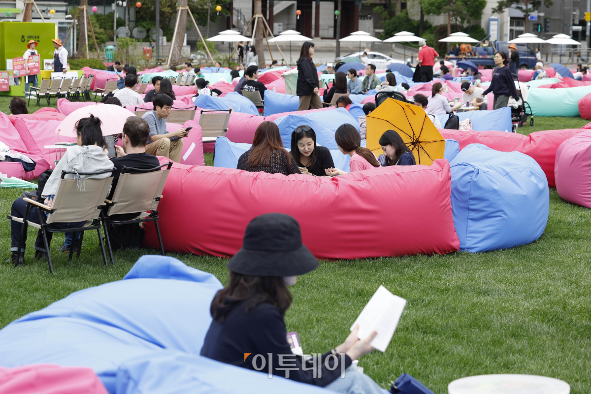 ▲서울야외도서관 개장 후 첫 주말을 맞은 21일 서울 중구 서울광장에 마련된 책읽는 서울광장을 찾은 시민들이 독서를 하며 휴식을 취하고 있다. 조현호 기자 hyunho@