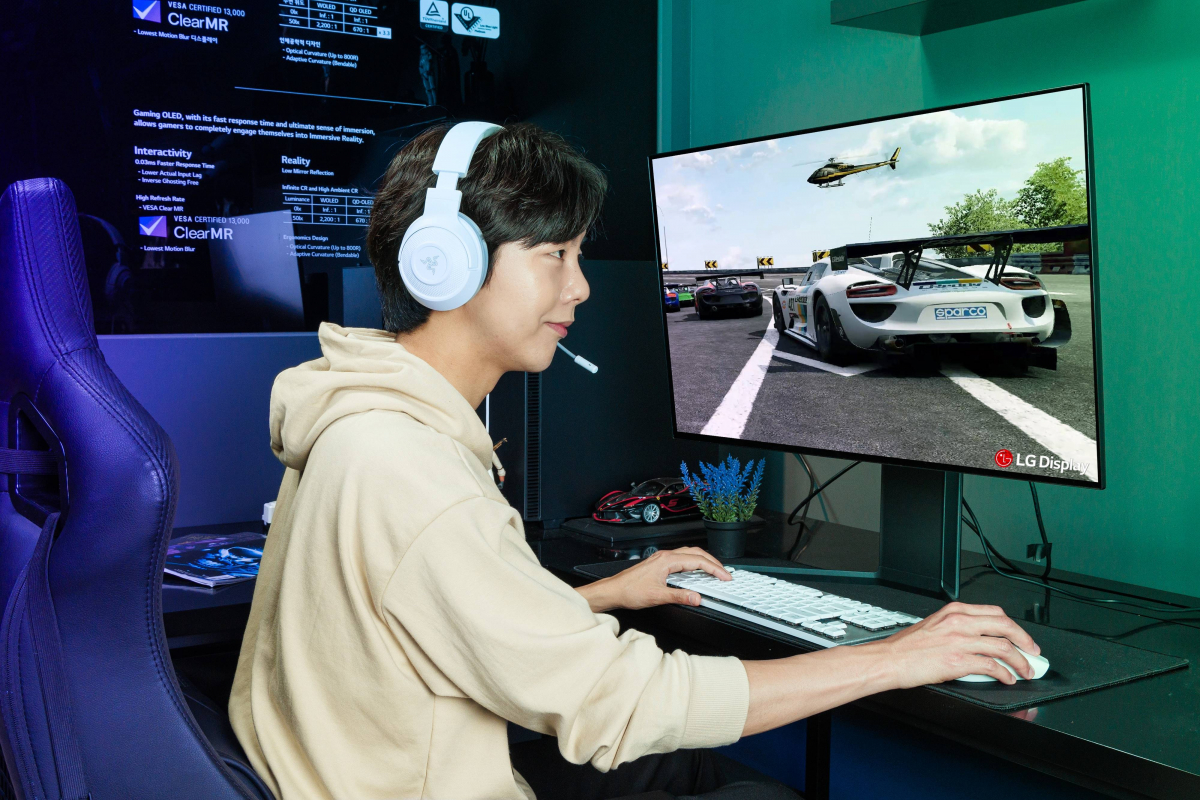 ▲LG디스플레이 모델이 '31.5인치 게이밍 OLED 패널'로 레이싱 게임을 하고 있다. (LG디스플레이 제공)