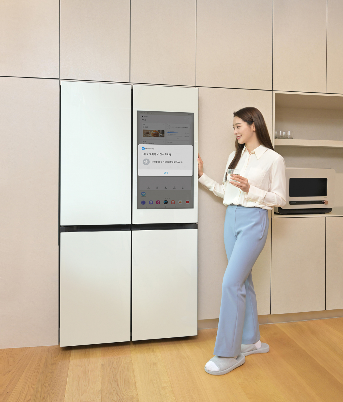 ▲삼성전자 모델이 비스포크 AI 패밀리허브 스크린으로 아카라 스마트 도어록과 연동된 스마트싱스 앱을 사용하고 있다. (자료제공=삼성전자)