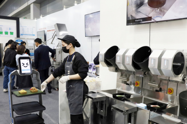 ▲조리자동 로봇인 오토웍이 만든 음식을 서빙로봇에 담고 있다. (사진제공=삼성웰스토리)