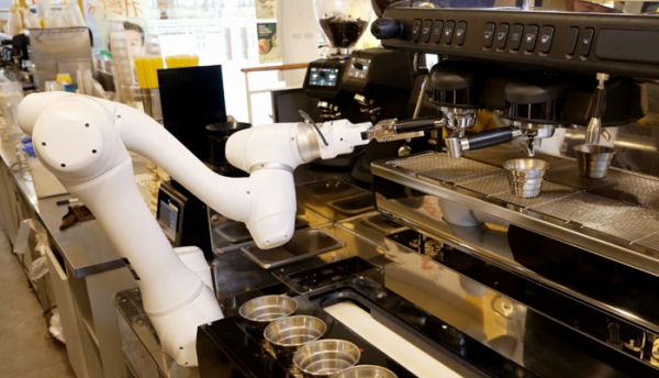 ▲두산로보틱스 협동로봇이 원두가 담긴 포터필터를 커피머신에 장착하고 있다. (사진제공=두산로보틱스)
