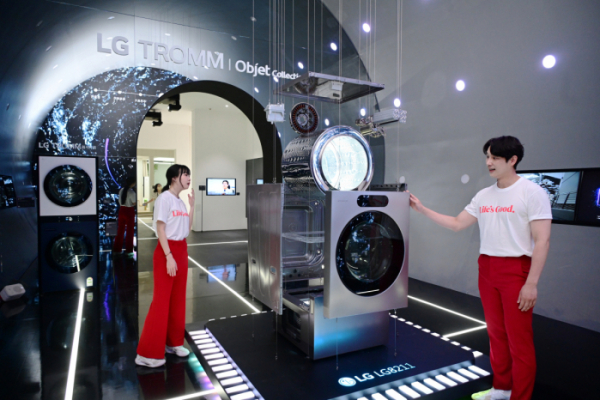 ▲17일 서울 코엑스에서 열리는 월드IT쇼에서 LG전자 모델들이 세탁부터 건조까지 한 번에 끝내는 'LG 시그니처 세탁건조기'의 ‘AI DD모터’와 ‘인버터 히트펌프’ 등 핵심 부품을 살펴보고 있다. (사진제공=LG전자)