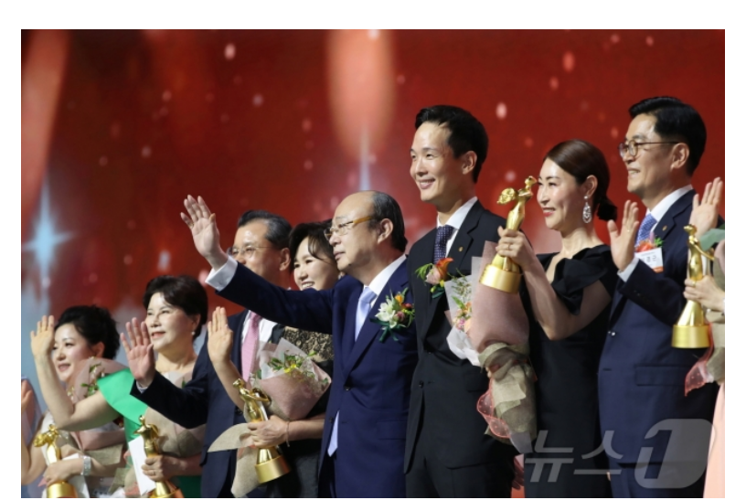 ▲한화그룹 김승연 회장(사진 왼쪽에서 다섯번째)이 한화생명금융서비스 연도대상 시상식에서 행사에 참석한 FP들의 환호에 손을 흔들며 인사하고 있다. (사진제공-한화생)