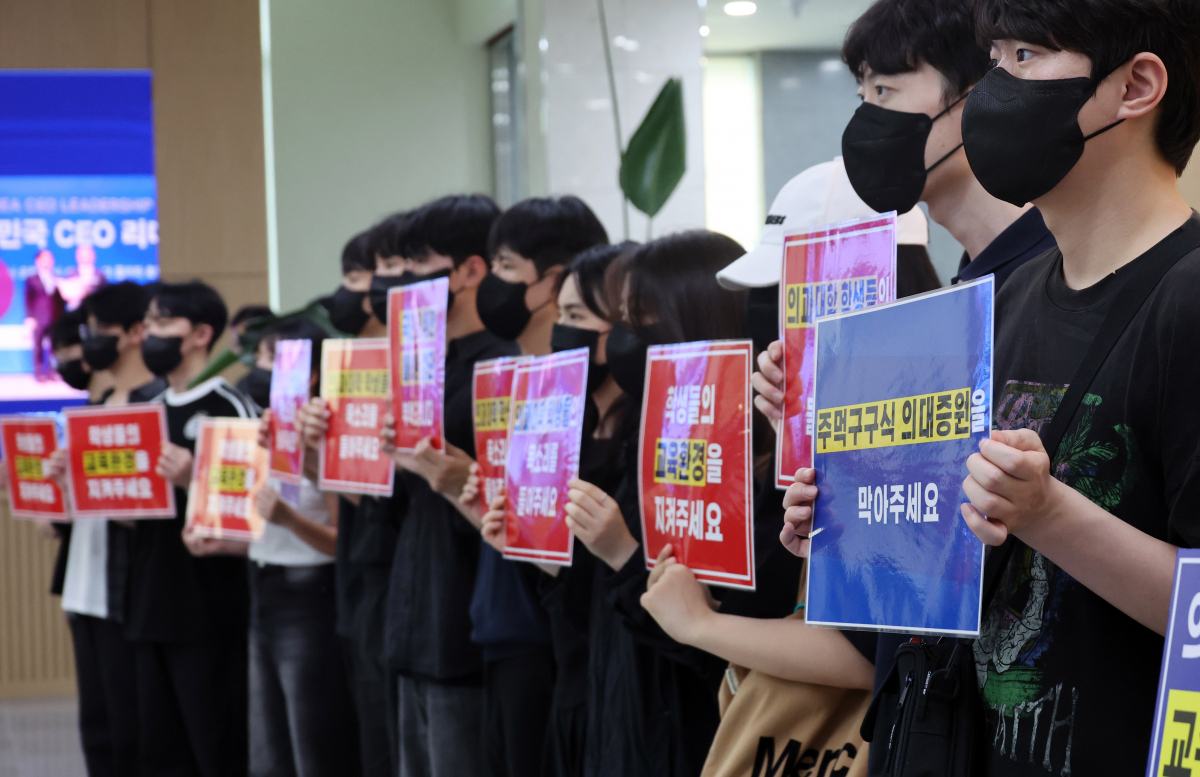 ▲의대 증원을 담은 학칙 개정을 위한 전북대학교 교수평의회가 열린 22일, 의대 교수 및 학생들이 대학 본부 현관 앞에서 손팻말을 들고 의대증원 반대를 촉구하고 있다. (연합뉴스)