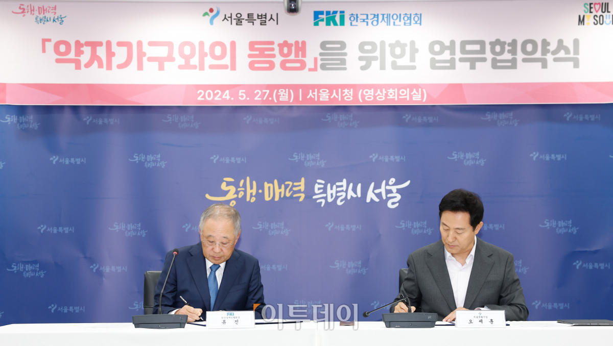 ▲오세훈(오른쪽) 서울시장과 류진 한국경제인연합회장이 27일 서울 중구 서울시청에서 열린 약자가구와의 동행을 위한 업무협약식에서 협약서에 사인을 하고 있다. 조현호 기자 hyunho@