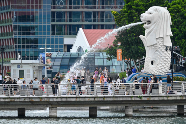 ▲사람들이 13일 싱가포르 마리나베이의 랜드마크인 머라이언 동상 옆에 사진을 찍기 위해 모여있다. 싱가포르/AFP연합뉴스