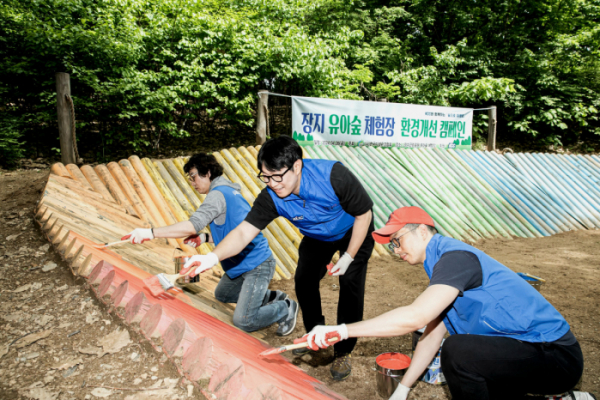 ▲KCC와 미래환경협회 직원들이 송파 장지 유아숲의 시설과 구조물을 보수하고 있다. (사진제공=KCC)