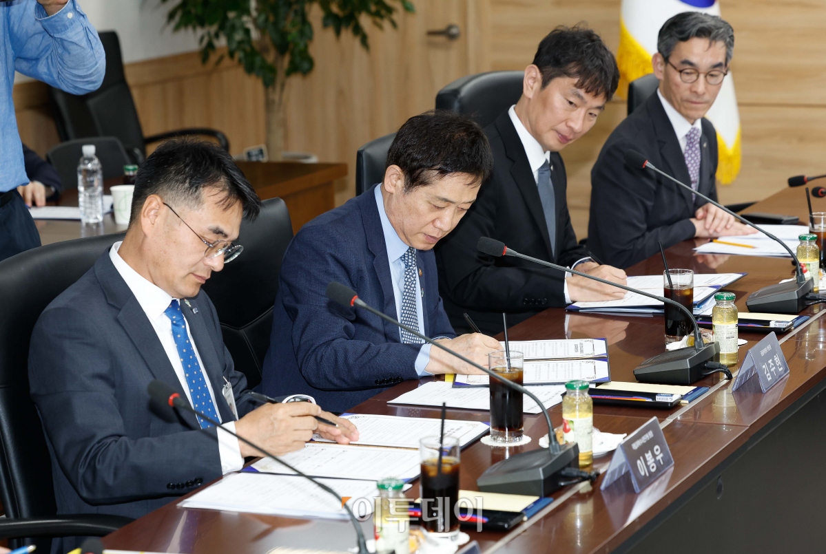 ▲3일 서울 종로구 정부서울청사에서 열린 AI·데이터 기반 보이스피싱 예방을 위한 업무 협약식에서 기관 대표들이 협약서에 사인을 하고 있다. 왼쪽부터 이봉우 국립과학수사연구원장, 김주현 금융위원장, 이복현 금융감독원장. 조현호 기자 hyunho@