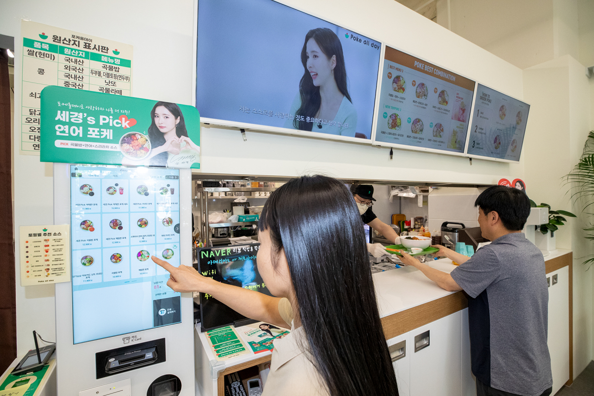 ▲KT가 ‘사장님TV’ 등 소상공인을 위한 미디어플랫폼 활용 상품으로 프랜차이즈 맞춤 서비스를 강화한다고 6일 밝혔다. 경기 고양시 일산동구에 위치한 포케올데이 백석점에서 고객이 ‘사장님TV’를 보고 주문하는 모습 (사진제공=KT)