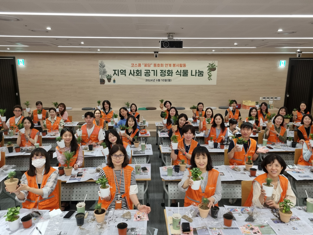▲12일 코스콤 임직원들이 본사 15층 강당에서 지역 소외이웃 대상 환경정화식물 기부를 위한 화분 식재 작업을 하고 기념사진을 촬영하고 있다. (사진=코스콤)