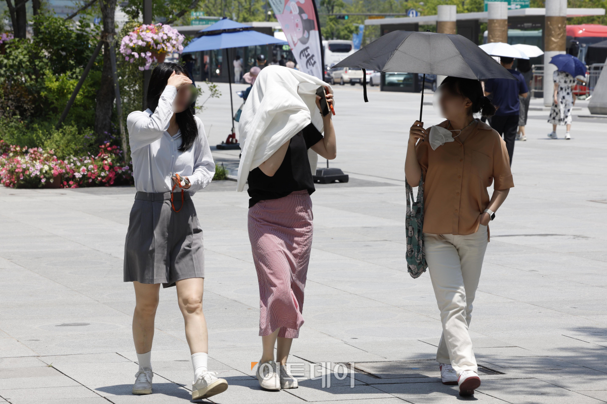 ▲서울 낮 최고기온이 35도까지 올라가는 등 올해 첫 폭염주의보가 내려진 19일 서울 종로구 광화문광장에서 시민들이 양산과 외투로 더위를 피하고 있다. 조현호 기자 hyunho@