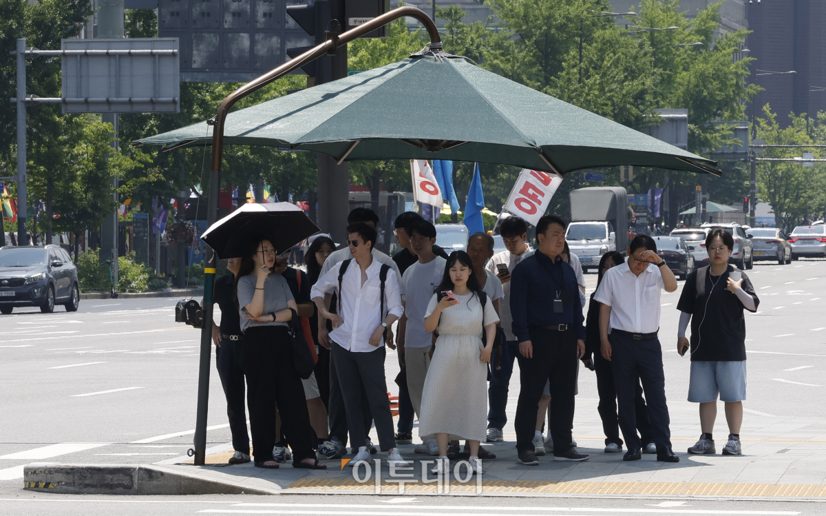 ▲서울 낮 최고기온이 35도까지 올라가는 등 올해 첫 폭염주의보가 내려진 19일 서울 종로구 광화문역 일대 그늘막에서 시민들이 더위를 피하고 있다. 조현호 기자 hyunho@
