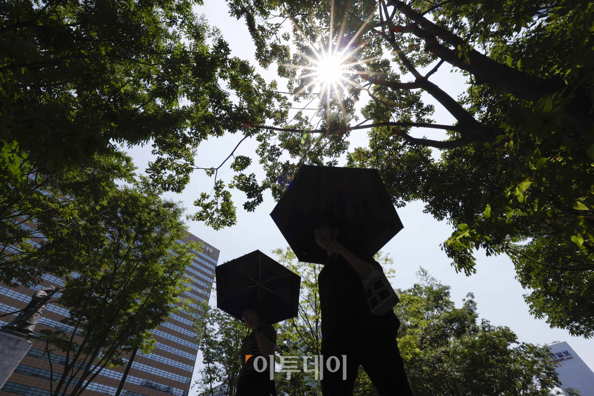 ▲서울 낮 최고기온이 35도까지 올라가는 등 올해 첫 폭염주의보가 내려진 19일 서울 종로구 광화문광장에서 양산을 쓴 시민들이 발걸음을 옮기고 있다. 조현호 기자 hyunho@
