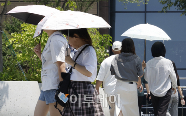 ▲서울 종로구 광화문광장에서 양산을 쓴 시민들이 발걸음을 옮기고 있다. 조현호 기자 hyunho@