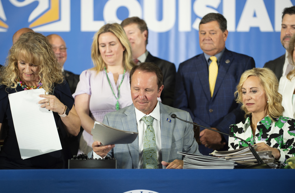 ▲제프리 랜드리(가운데) 미국 루이지애나 주지사가 19일(현지시간) 라파예트에 있는 아워 레이디 오브 파티마 가톨릭 스쿨에서 십계명이 담긴 포스터를 모든 공립학교 게시하는 것을 의무하하는 법안에 서명하고 있다. 라파예트(미국)/AP연합뉴스