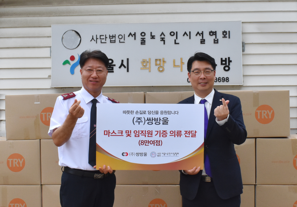 ▲이형석 쌍방울 대표(오른쪽)와 장경환 서울노숙인시설협회장이 20일 서울시 성동구 서울노숙인시설협회 희망옷나눔창고에서 기부식을 갖고 기념촬영을 하고 있다.(쌍방울 제공)