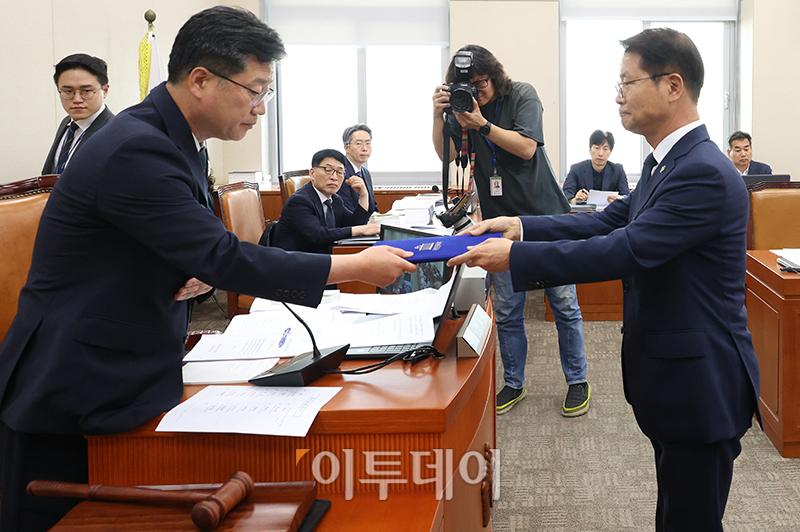 ▲이정식(오른쪽) 고용노동부 장관이 27일 서울 여의도 국회 환경노동위원회에서 열린 '노란봉투법'(노동조합 및 노동관계조정법 일부개정법률안)에 대한 입법청문회에서 증인선서를 마치고 더불어민주당 소속 안호영 위원장에게 선서문을 전달하고 있다. 고이란 기자 photoeran@