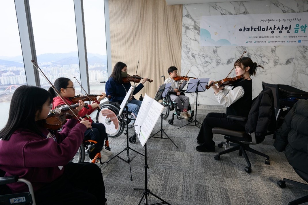 ▲2월 24일 서울 영등포구 상상인증권 여의도 본사에서 열린 ‘2024 아카데미 상상인 음악캠프’에서 휠체어 사용 아동들이 바이올린 연주 교육을 받고 있다. (사진제공=상상인그룹)