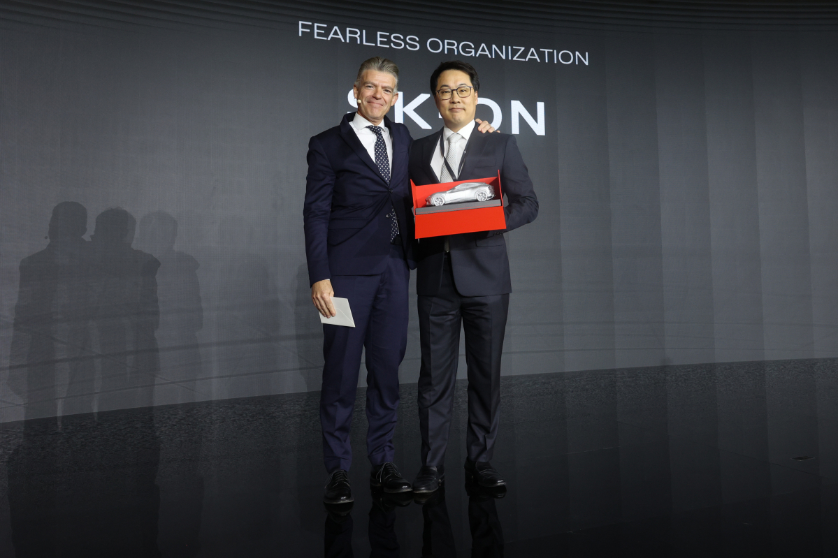 ▲정구필 SK온 EU세일즈 담당(오른쪽)과 지안마리아 풀겐지 페라리 최고 제품개발 책임자(CPDO)가 26일(현지시간) 이탈리아 마라넬로에서 열린 ‘포디오 페라리’ 행사 중 기념 촬영을 하고 있다. (사진제공=SK온)