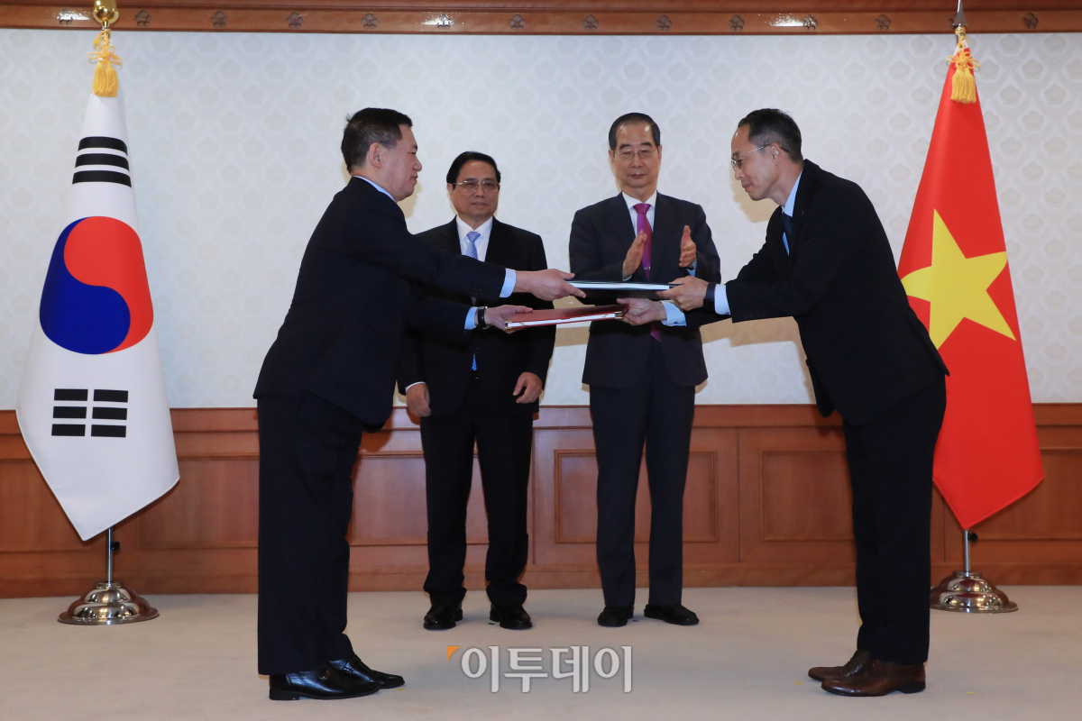 ▲황기연 수출입은행 상임이사(오른쪽)와 호 득 퍽 베트남 재무부 장관이 2일 서울 종로구 정부서울청사에서 열린 한국-베트남 간 양해각서 및 계약 교환식에서 한덕수 국무총리(뒷줄 오른쪽)와 팜 민 찡 베트남 총리가 참석한 가운데 문서를 교환하고 있다. 청사사진기자단