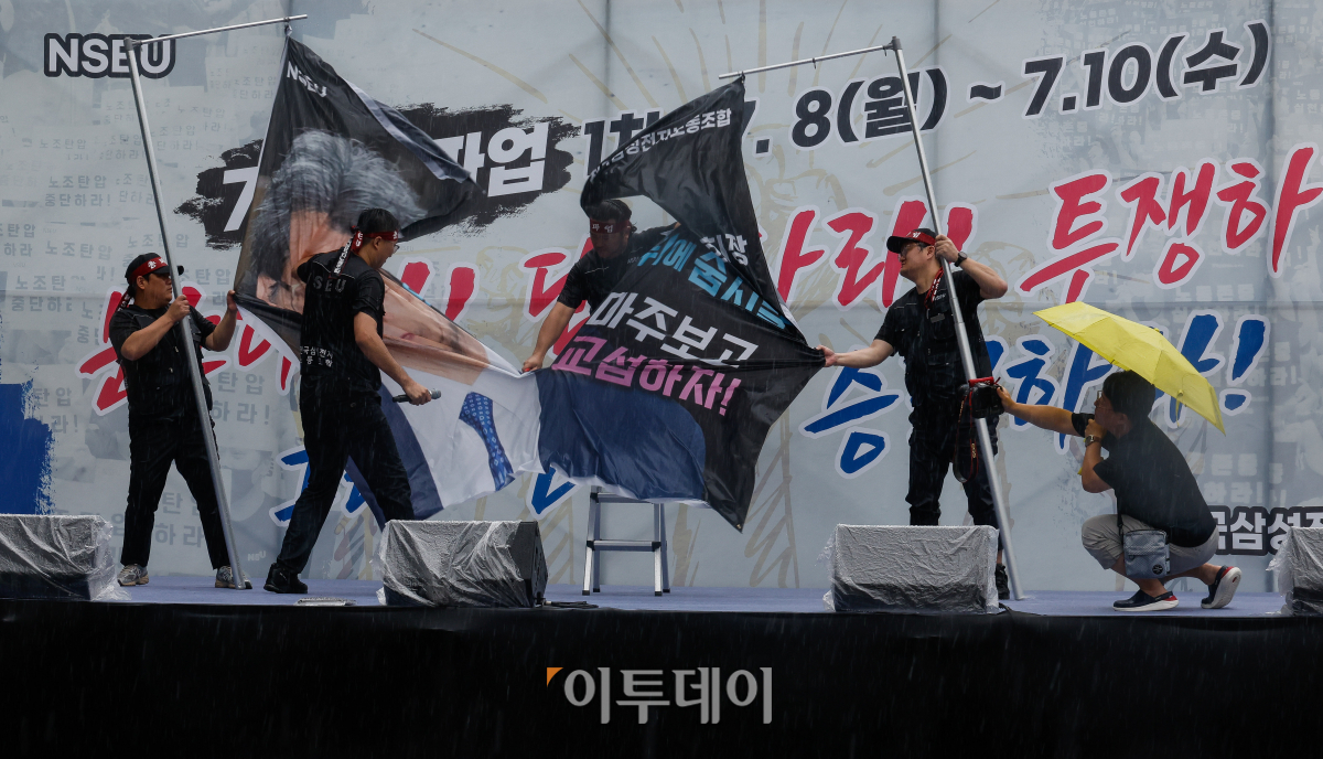 ▲전국삼성전자노동조합이 8일 경기 화성시 삼성전자 화성캠퍼스 H1 앞에서 열린 총파업 결의대회에서 정현호 삼성전자 부회장 얼굴이 담진 현수막을 찢는 퍼포먼스를 하고 있다. 조현호 기자 hyunho@