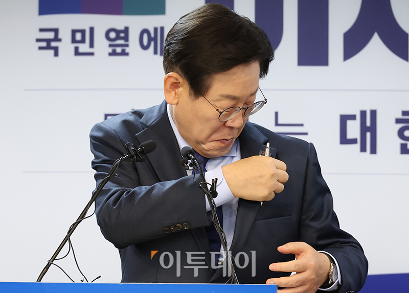 ▲이재명 더불어민주당 전 대표가 10일 서울 여의도 당사에서 당 대표 출마 선언 기자회견 중 태극기 배지의 방향이 잘못됐다는 한 기자의 지적에 배지를 고쳐달고 있다. 고이란 기자 photoeran@