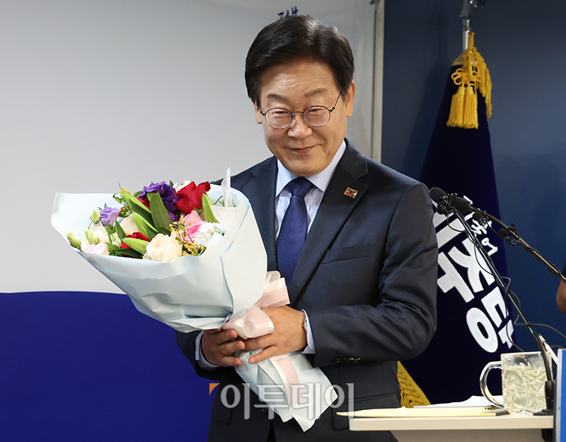 ▲이재명 더불어민주당 전 대표가 10일 서울 여의도 당사에서 당 대표 출마 선언 기자회견에 앞서 지지자에게 받은 꽃다발을 들고 입장하고 있다. 고이란 기자 photoeran@